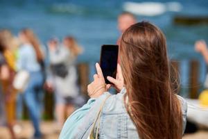 mujer tomando fotos en el teléfono, grabando videos con la cámara del teléfono, usando un teléfono inteligente para tomar fotos