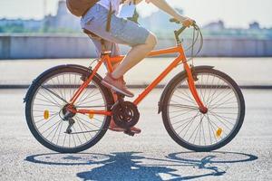 mujer joven montando en bicicleta en la carretera de la ciudad foto