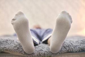 Woman resting on sofa in white striped socks, close up. photo