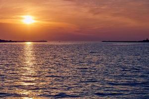 Calm sea with sunset sky, beautiful panoramic view, amazing dramatic rising sun reflected in water photo