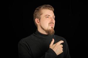 Thoughtful bearded man, half profile portrait, black background photo