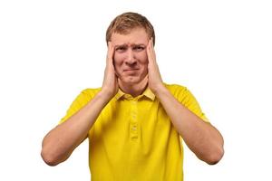 Upset young male in yellow T-shirt clutched at head, forgetful man, isolated on white background photo