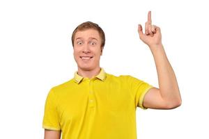 Smiling young guy in yellow T-shirt with eureka gesture, man got idea, isolated white background photo