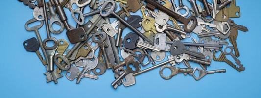 Keys set on blue background. Door lock keys and safes for property security and house protection. Different antique and new types of keys. photo