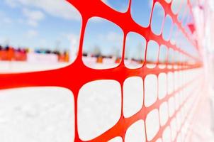 Safety outdoor slope track fence, winter background. Fence to protect spectators at sports events, or to indicate course at extreme sports - dog sledding, snowboarding or skiing photo