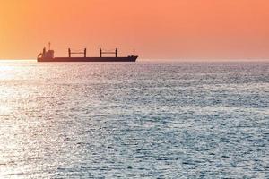 barcaza en la hermosa puesta de sol. anclaje para barcos, copie el espacio. increíble paisaje marino nocturno, impresionante vista de viaje. foto