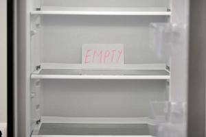 Empty refrigerator concept. Empty shelves of new refrigerator. Weight loss diet concept. photo