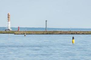 Jetty with towers and buoys. Beautiful seascape, copy space. Breakwater for protect ships at shipyard from waves photo
