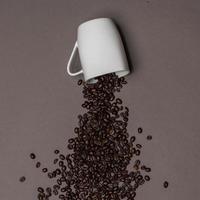 granos de café y taza blanca sobre fondo de color foto