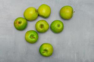 Fresh ripe green apples on a grey rustic table photo