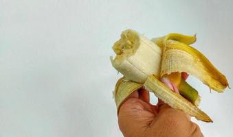 plátano maduro en la mano izquierda. foto