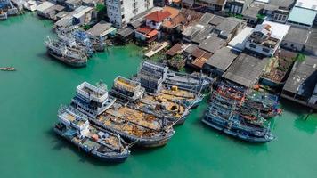 vista aérea del muelle de pescadores que tiene muchos barcos anclados para transportar mariscos y suministros en la isla de songkhla, tailandia foto