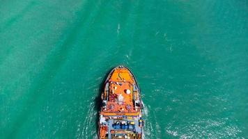 vista aérea en la parte superior del buque de carga que transporta un contenedor y se ejecuta para exportar el puerto del patio de carga al océano personalizado internacional. concepto de transporte de tecnología, despacho de aduanas, banner de seminario web. foto