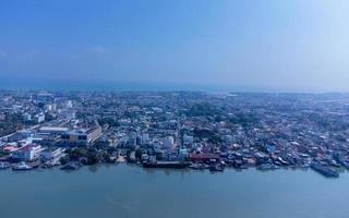 barcos de pesca en un pueblo de pescadores reflexionando sobre el agua. la vida de un pueblo de pescadores en la costa de songkhla, tailandia desde la vista de pájaro de un dron. foto