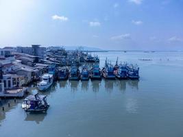 vista aérea del muelle de pescadores que tiene muchos barcos anclados para transportar mariscos y suministros en la isla de songkhla, tailandia foto