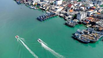 vista aérea del muelle de pescadores que tiene muchos barcos anclados para transportar mariscos y suministros en la isla de songkhla, tailandia foto