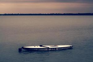 A small boat in a large body of water photo