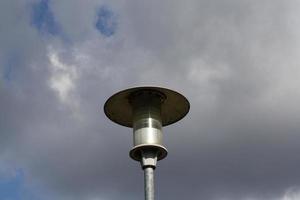 A close up of a street lamp in front of a cloudy sky photo