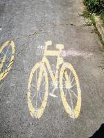 carril bici marcando pintura amarilla en la acera foto