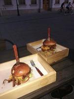 A hamburger sitting on top of a wooden table photo