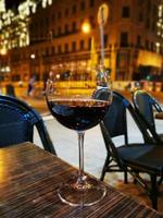 A glass of wine sitting on top of a wooden table photo