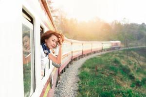 Woman looks out from window traveling by train photo