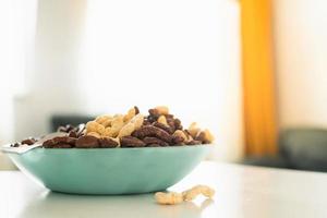 Bowl of cereals in bright kitchen on white table in green plate for kids breakfast before school photo