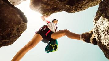 Low angle close up one young caucasian sporty woman alone train rock climb outdoors in sunny hot weather alone. Inspirational active strong woman sports activities outdoors photo