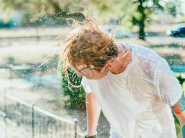 portrait of Caucasian man shaking head with water splashes. Summer fun, party, vacation, emotions, pleasure, relaxation, refreshment concept photo