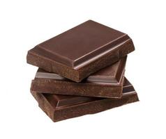 barras de chocolate oscuro aisladas sobre fondo blanco. pila de trozos de chocolate, primer plano foto