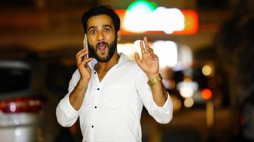 Portrait Of Handsome indian Man Talking On Cellphone night image with excitement photo