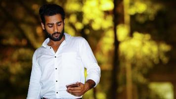 hombre usando móvil joven guapo al aire libre imagen nocturna foto