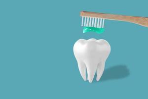 Holding toothpaste and toothbrush near tooth model on blue background. People teeth hygiene. Empty place for text, quote, sayings or logo. Closeup. Dental concept. photo