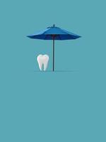 diente bajo una sombrilla de playa sobre un fondo azul. concepto de dentista. anuncios de odontología. concepto de salud dental. foto