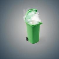 Green trash bin can from which smoke comes. On a dark gray background. Minimal concept. photo