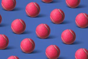 Pattern pink tennis balls on a dark blue background. Flat lay. photo