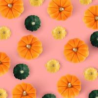 Pattern with autumn pumpkins and green, yellow pattypan squash on pink background. Fall autumn halloween concept. Flat lay, top view. Autumn pattern. photo