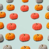 Autumn colorful pattern of pumpkins on pastel blue background with copy space. Trendy halloween pattern with different color pumpkins. Creative autumn, fall concept. Side view. photo