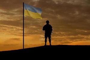 Soldier of the Army of Ukraine with the state flag. Greeting card for Defenders Day, Remembrance Day, Independence Day. Copy space. photo