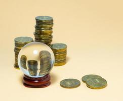 Pyramids of coins are reflected in a glass ball. photo