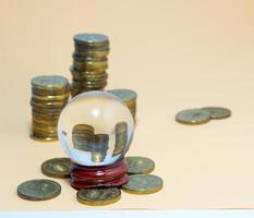 Pyramids of coins are reflected in a glass ball. photo