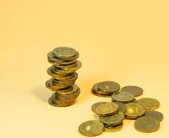 Turret  made of coins. Money on yellow background photo