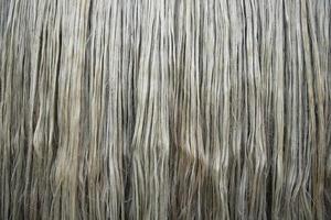 Closeup shot of raw jute fiber hanging under the sunlight for drying. Brown jute fiber texture and  background photo