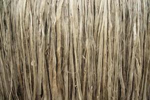 Closeup shot of raw jute fiber hanging under the sunlight for drying. Brown jute fiber texture and  background photo