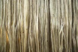 Closeup shot of raw jute fiber hanging under the sunlight for drying. Brown jute fiber texture and  background photo