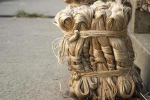 A thick brown  bundle of  raw jute has on the ground photo