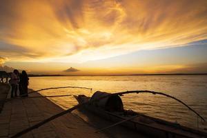 un barco de madera en el mar contra el cielo durante la puesta de sol foto