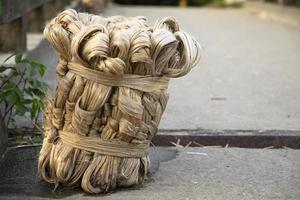 A thick brown  bundle of  raw jute has on the ground photo