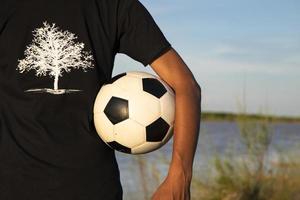Man holding a soccer ball on the Riverside field photo