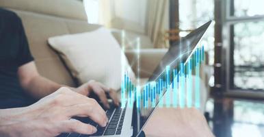 Man hand typing laptop keyboard with bullish financial stock graph profit increase photo
